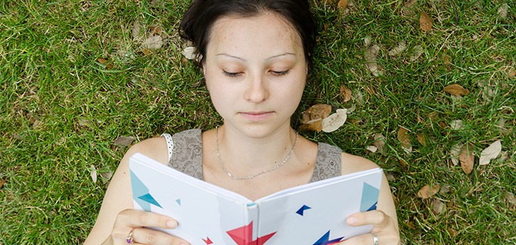 étudiante qui li dans l'herbe